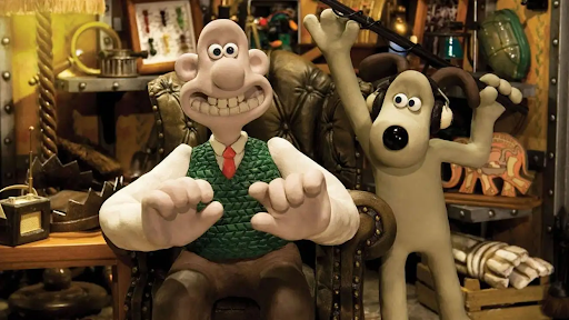 Wallace sitting in a leather chair, with Gromit holding a microphone above him.